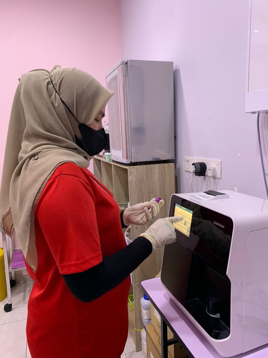 Clinic staff operating a lab analyser at Klinik Dr. Prevents Bandar Sri Damansara